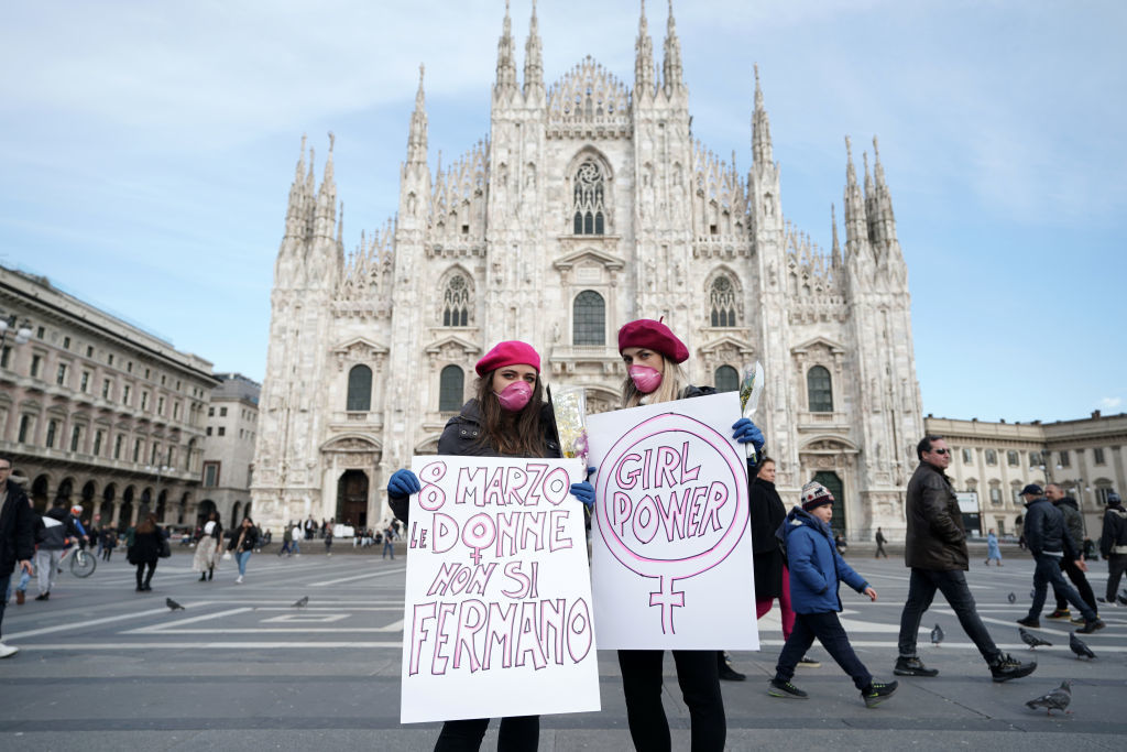 Как се празнува Денят на жената в Милано? С плакати за силата на нежния пол, опънати пред Дуомо.
