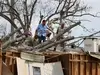Работници отстраняват дърво от покрива на къща, паднало върху нея по време на урагана Айда през август 2021 г. в САЩ